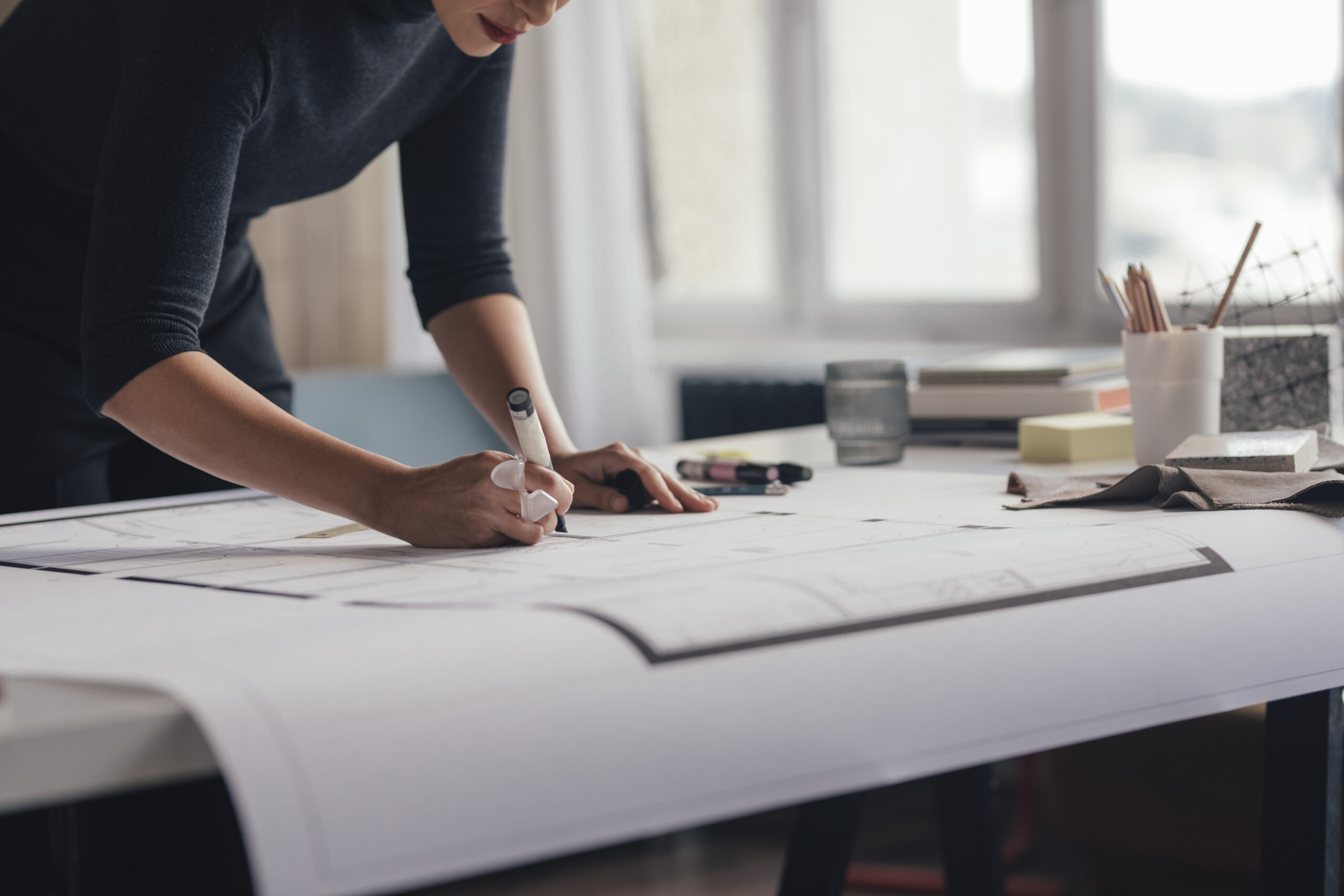 An unrecognizable young architect working on a project in her studio.